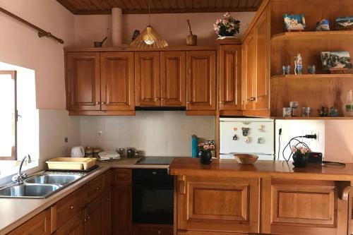 una cocina con armarios de madera y fregadero en Anastasia’s Home, 