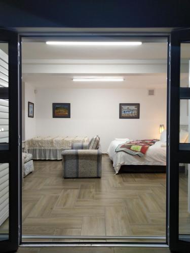 a living room with two beds and a sliding glass door at Somerset View Guest House in Somerset West