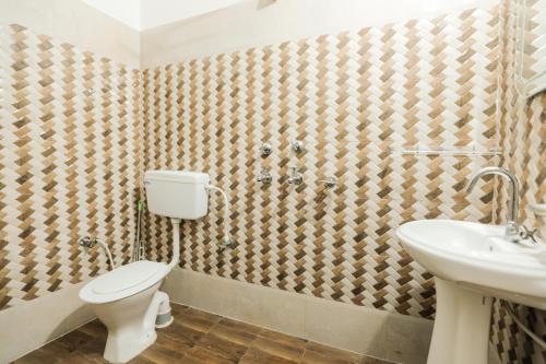 a bathroom with a toilet and a sink at Hotel Grand Galaxy in Rishīkesh