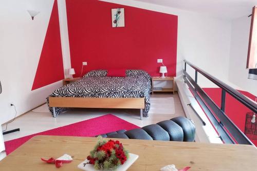 a bedroom with a bed and a red wall at Honeycomb - casa vacanze in Varese