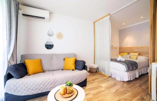 un salon avec un canapé et un lit dans l'établissement Cosy Center - Rue d'antibes - 200m plage- Clim - wifi - Unique, à Cannes