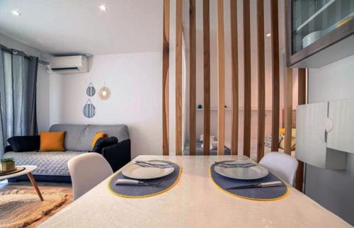 un salon avec une table et un canapé dans l'établissement Cosy Center - Rue d'antibes - 200m plage- Clim - wifi - Unique, à Cannes