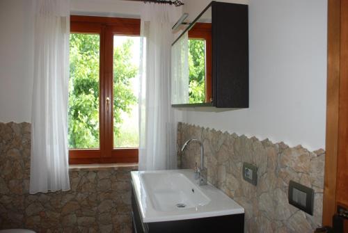 a bathroom with a sink and a window at B&B Profumo delle Marche in Montefano