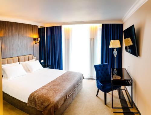 a bedroom with a bed and a desk and a chair at Lion's Hotel in Chişinău