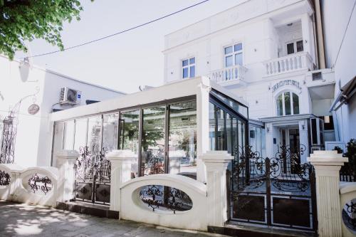 a white building with a glass storefront at Hotel Bela Kuka in Bitola