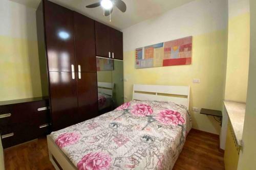 Un dormitorio con una cama con flores rosas. en Un tocco provenzale a Savigliano, en Savigliano