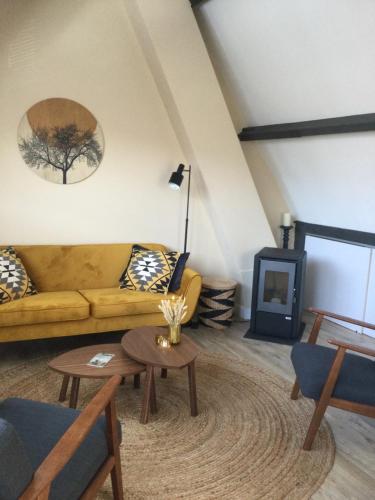 sala de estar con sofá y chimenea en Vakantiehuis De Oude Bakkerij, en Katwijk aan Zee