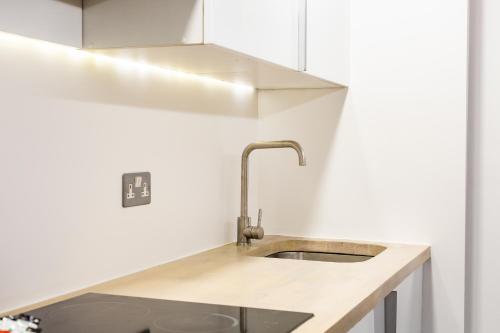 a kitchen with a sink and white cabinets at St Michaels Place in Bristol
