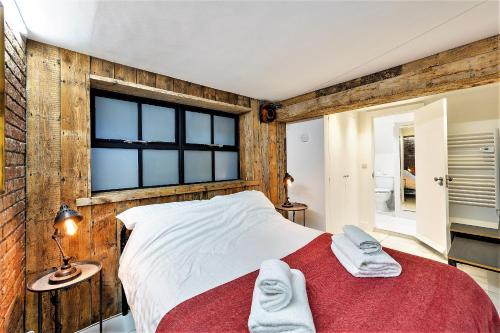 um quarto com uma parede de madeira, uma cama e uma janela em St Michaels Place em Bristol