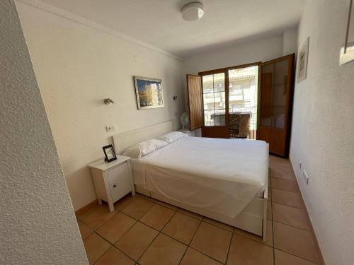 ein Schlafzimmer mit einem weißen Bett und einem Fenster in der Unterkunft AR27-4 Impresionantes vistas al mar. in Villajoyosa