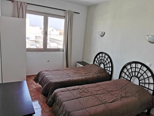 コティージョにあるCotillo Faroのベッド2台と窓が備わるホテルルームです。