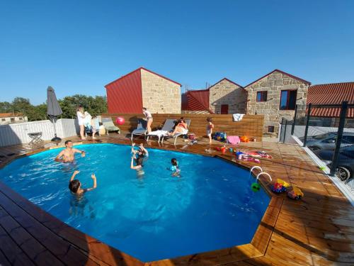 un groupe de personnes jouant dans une piscine dans l'établissement Casas de Penedones - Ventos da Cabreira, à Penedones