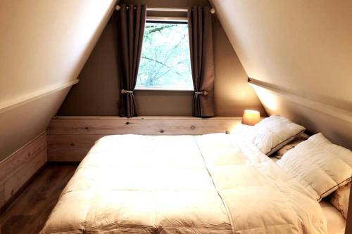 a bed in a room with a window at Tipi d'Amis in Durbuy