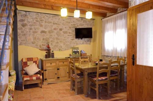 a dining room with a table and chairs and a television at Casa Rural Ca Lazaro in Bot