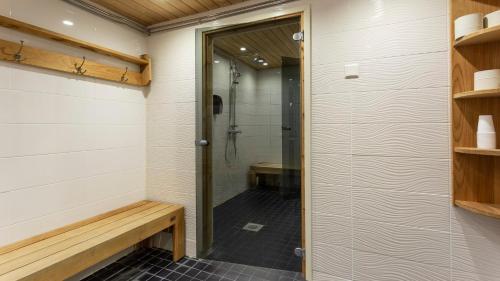 uma cabina de duche ao nível do chão com uma porta de vidro na casa de banho em Motel Käpylä em Keminmaa