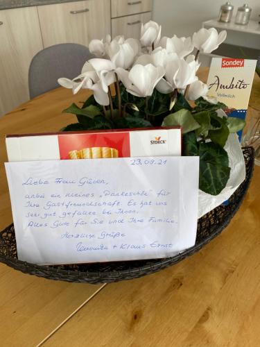 a bouquet of white flowers in a basket on a table at Olive in Uhldingen-Mühlhofen