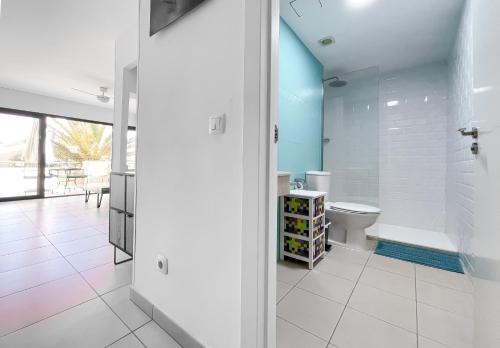 a bathroom with a toilet and a glass shower at Atlantic Garden 238 by Best Holidays Fuerteventura in Corralejo