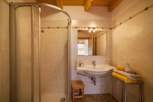 a bathroom with a shower and a sink at Tonigbauernhof Blumenwiese in Schenna