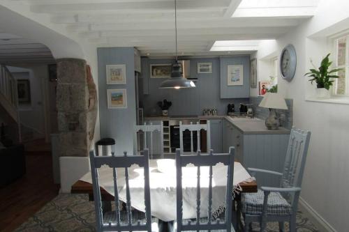 a kitchen with a table and chairs in a room at Lovely Spacious Cottage Near The Coast in St Austell