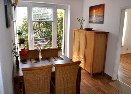 ein Esszimmer mit einem Holztisch und Stühlen in der Unterkunft Ferienhaus Pension Sonnenblume in Elmenhorst