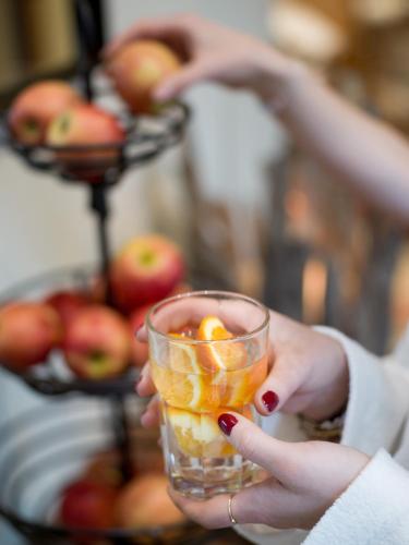 a woman holding a glass with fruit in her hands at Alpin Family Resort Seetal in Kaltenbach