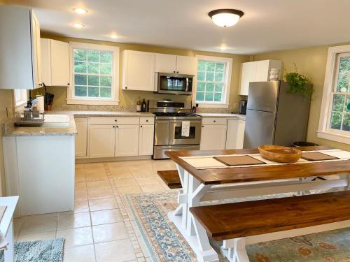 cocina con armarios blancos y mesa de madera en 1860's Colonial House Near Downtown and Beaches!, en Madison