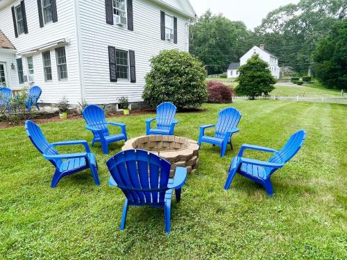 a group of blue chairs around a fire pit in a yard at 1860's Colonial House Near Downtown and Beaches! in Madison