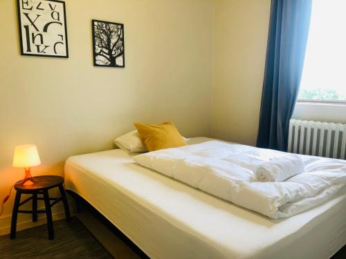 a bedroom with a white bed with a window at Paradise Cave Hostel & Guesthouse in Seljaland