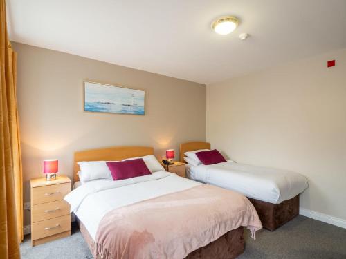 een slaapkamer met 2 bedden en 2 nachtkastjes met lampen bij The Woodfield Hotel in Clifden