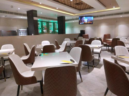 a dining room with white tables and chairs at THE HOTEL PARK in Kolachel