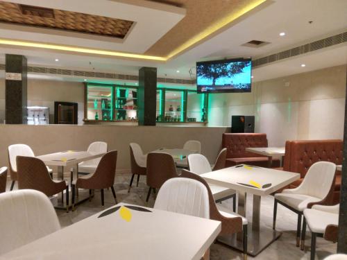 a restaurant with tables and chairs and a tv on the wall at THE HOTEL PARK in Kolachel