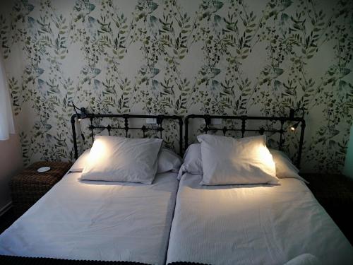 um quarto com uma cama com lençóis brancos e papel de parede em Luminoso Loft em Monforte de Lemos