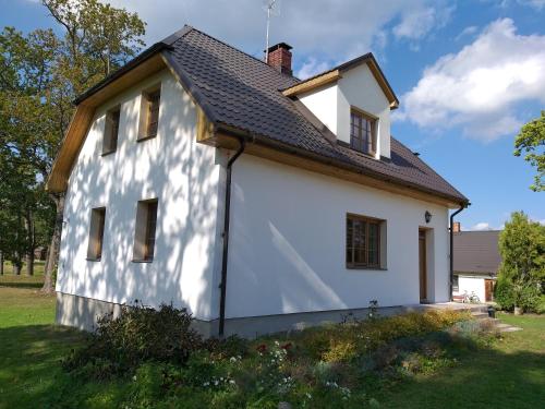 a white house with a black roof at Brīvdienu māja Dukāti in Cesvaine