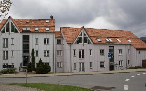 ein großes weißes Gebäude mit roten Dächern auf einer Straße in der Unterkunft Wurmberg in Sicht -Ferienwohnung Schulte in Schierke
