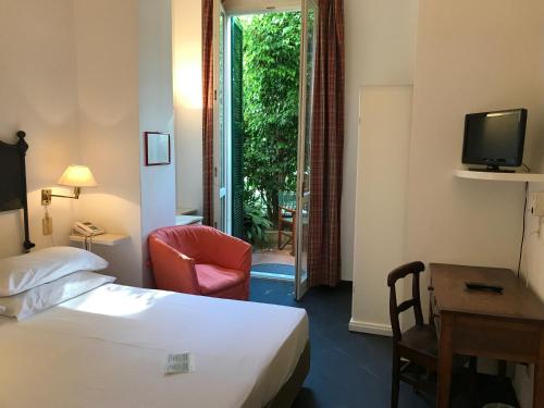 a hotel room with a bed and a desk and a chair at Hotel Beau Rivage in Alassio