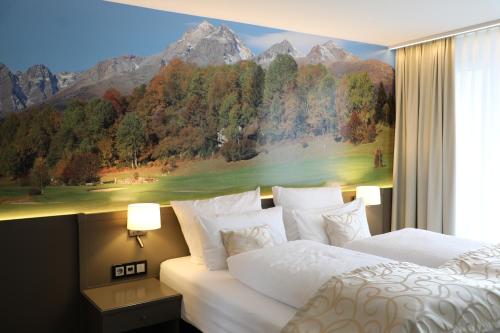 a bedroom with two beds and a painting on the wall at Alpenlodge Val Gronda in Obersaxen