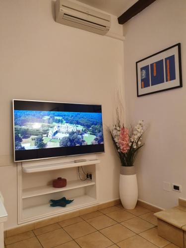 a living room with a flat screen tv on a wall at Giulia House via dell Ariento 5 Firenze in Florence