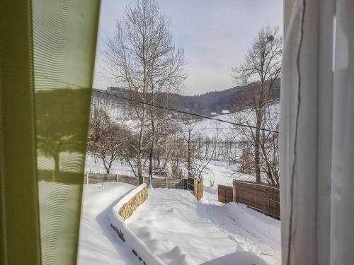 a view of a snow covered field from a window at Sadyba Zatyshok in Maidan Village
