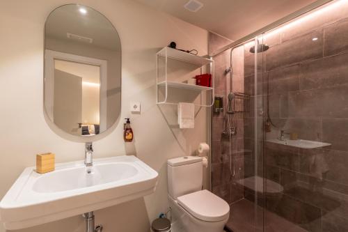 y baño con lavabo, aseo y ducha. en ToledoRooms VistaPark - Suites, en Toledo