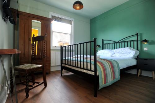 a bedroom with a bed and a chair and a window at Beechurst Serviced Apartments in Cheltenham