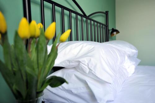a vase of yellow flowers sitting next to a bed at Beechurst Serviced Apartments in Cheltenham