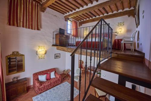 a living room with a spiral staircase in a house at Villa Curina Resort in Castelnuovo Berardenga