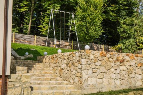 a stone retaining wall with stairs and a fence at Sadyba Zatyshok in Maidan Village