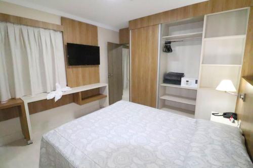 1 dormitorio con 1 cama blanca en una habitación en Piazza Acqua Park Reservas, en Caldas Novas