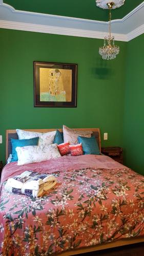 a bedroom with a large bed with green walls at Malvelyns am Bodensee in Immenstaad am Bodensee