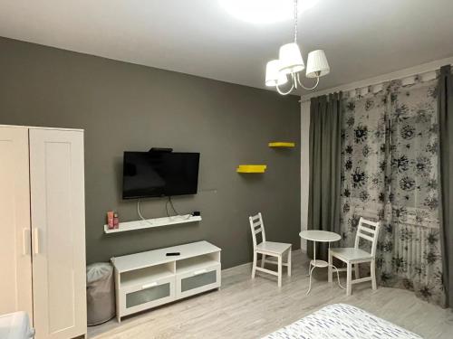 Cette chambre comprend un lit, une table et des chaises. dans l'établissement Centru charming new apartament piata universitate, à Bucarest
