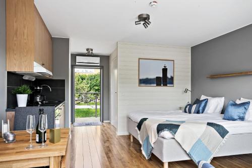 1 dormitorio con 1 cama grande y cocina en Skärgårdsbyn Hotell, en Sankt Anna