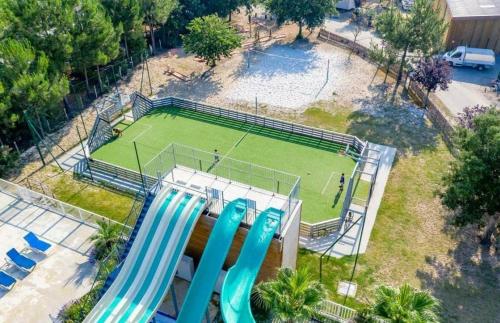 an aerial view of a tennis court with two blue slides at Camping des Dunes de Contis mobilhome 3ch, in Saint-Julien-en-Born
