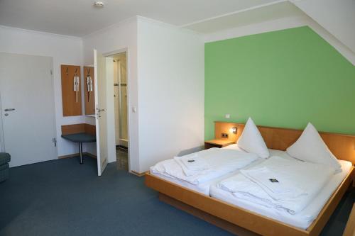 a bedroom with a large bed with a green wall at Zu Müllers Winkelhausen in Langenmosen
