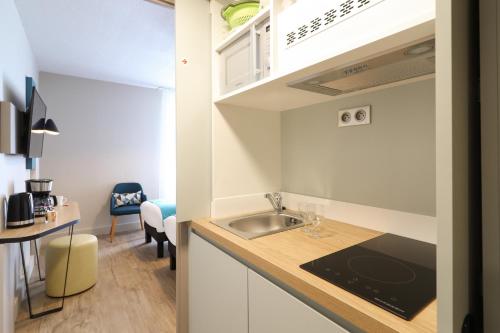 a small kitchen with a sink and a table at Appart'City Confort Toulouse Diagora Labège in Labège